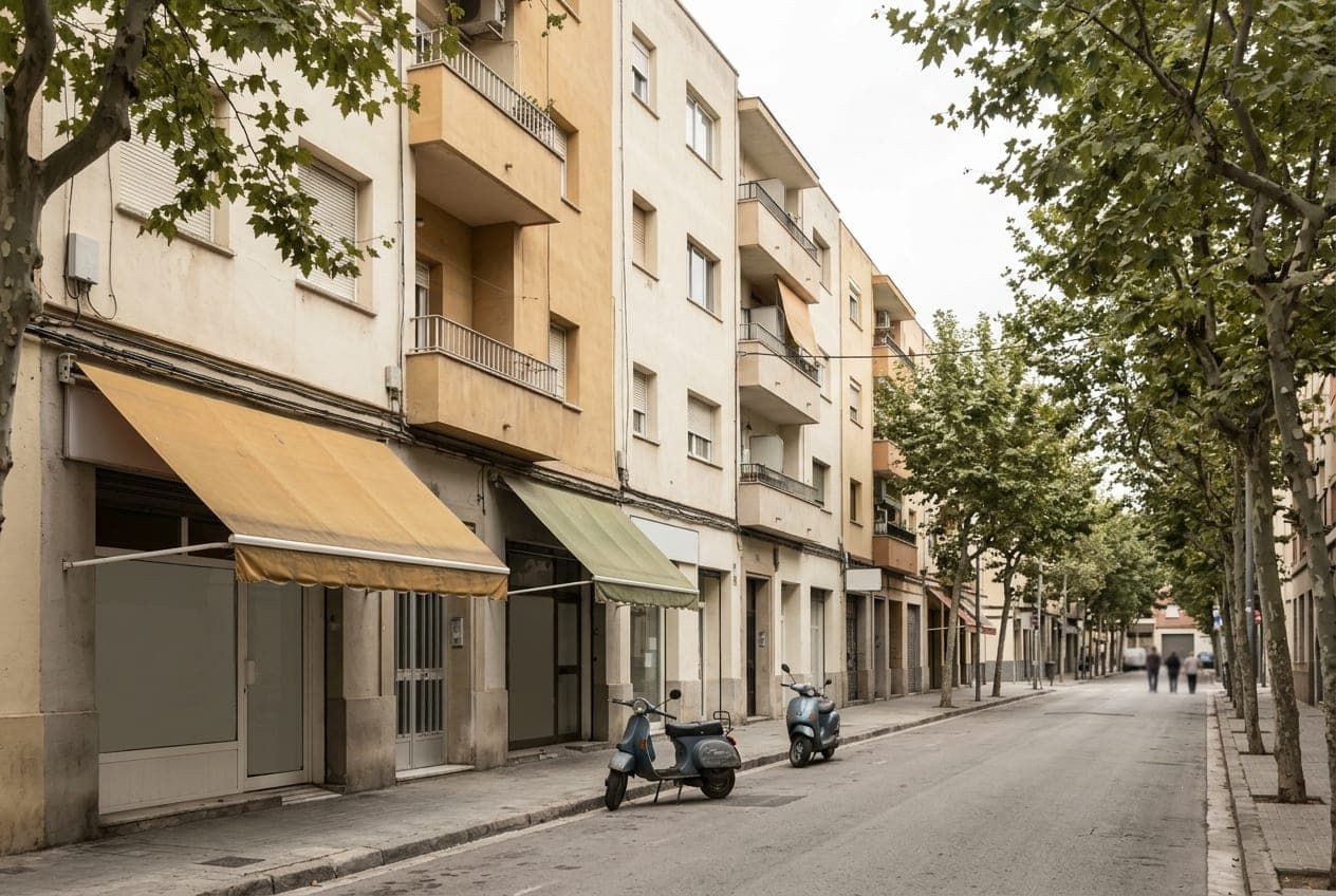 Una calle de barrio con árboles, toldos y dos motos aparcadas